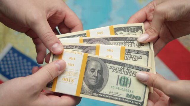 Diplomats exchange funds by hands against American and French flags with global map, symbolizing cultural-economic ties.