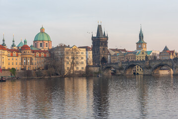 Fototapeta premium Sunset view of Charles bridge and Saint Salvator church in Pragu