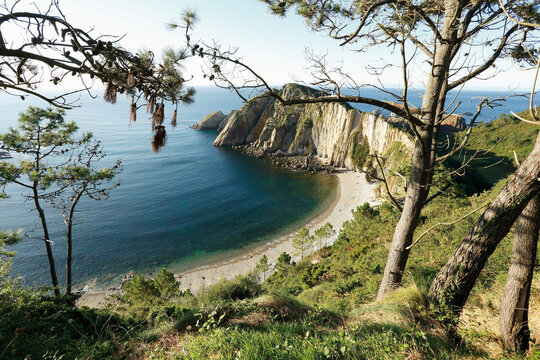 breathtaking crescent moon bay in asturias, spain. silencio beach features towering cliffs, crystal clear waters, and a serene, untouched pebble shore.
