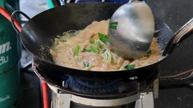 Street Food Thai Omelette Cooking in Wok on Gas Burner Bangkok Thailand