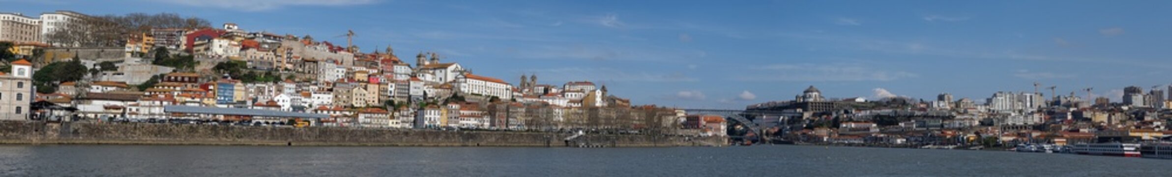 Panoramic view of Porto riverside cityscape with colorful houses and historic architecture by Douro river