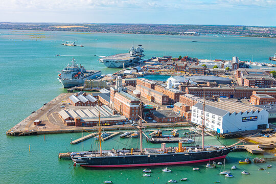 HMS Warrior battle ship and modern aircraft carriers at port of