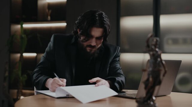 Male lawyer studying contracts and case files, Themis statue nearby. Legal work concept.
