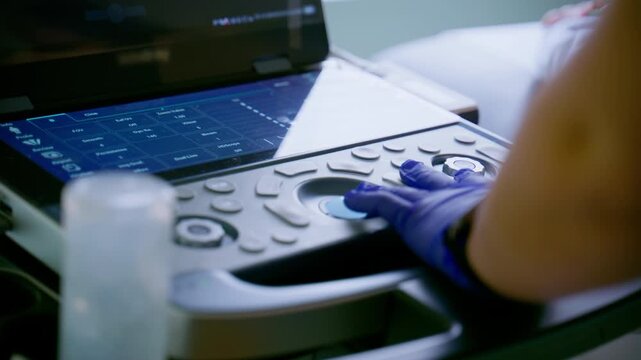 Doctor operating ultrasound machine while performing diagnostic scan patient in modern medical clinic, 