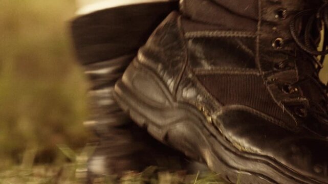 close up of tactical boots walking on grass