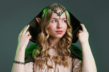 Obraz premium Beautiful girl dressed as elf on grey background