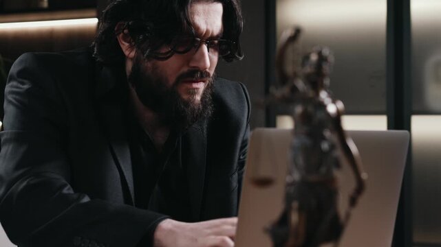 Male lawyer preparing legal documents, Themis statue on desk. Justice and law concept.
