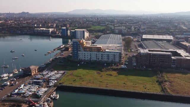 Modern residential housing development by a sailing yacht marina and coastal beach in Scotland