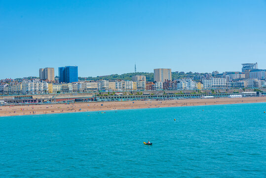 People are enjoying a sunny day on a beach in Brighton, England