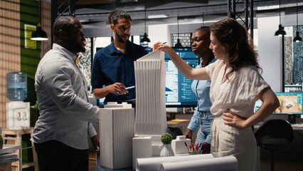 Diverse team of developers sharing construction details in a briefing session, urban development...