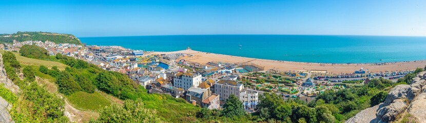 Naklejka premium People are enjoying a sunny day on a beach in Hastings, England