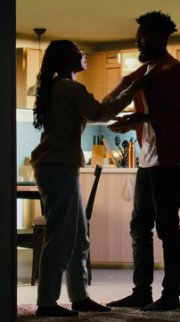 Vertical Video Young black people fighting in dark hallway looking angry and enraged during heated disagreement. Unhappy furious couple in conflict, relationship drama due to constant yelling and