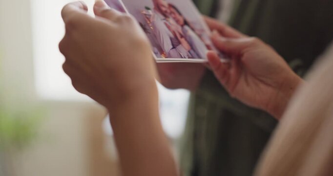 Couple breakup separation memories in photos and hands. They sort printed snapshots of happy times, reflecting on relationship nostalgia and lost moments. Clear visual metaphor of separation.