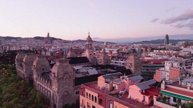 Aerial drone flying over barcelona cityscape at sunset