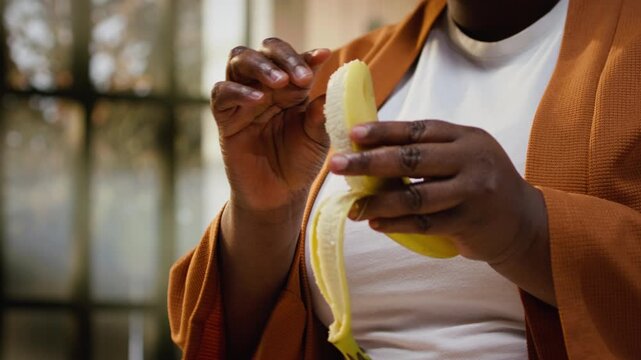 Content creator pealing a banana and adding slices on chia bowl, preparing a healthy breakfast meal for online audience. Woman filming meal prep with fruits and yogurt, chia pudding.