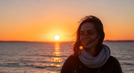 Fototapeta premium Young woman smiling at the beach during a beautiful golden sunset over the ocean