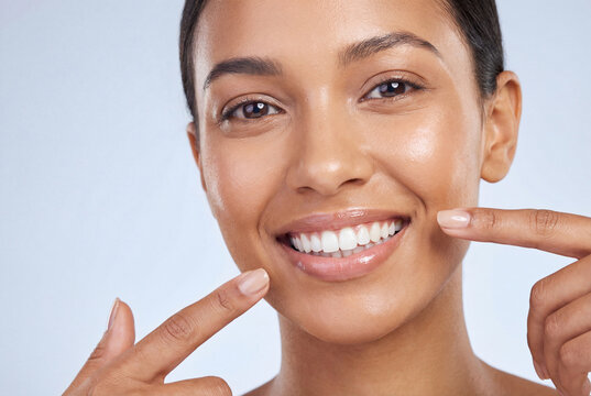 Woman pointing at her perfect white teeth and smile