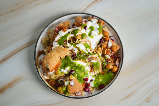 Samosa chana chaat with yogurt, tamarind chutney, mint chutney & chickpeas - Traditional indian street food top view
