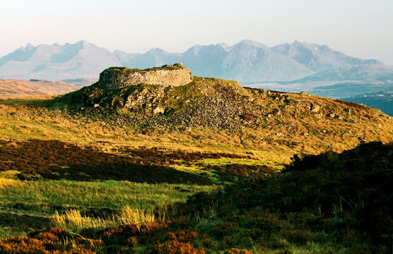 Double walled Dun Beag Broch 2000 year old circular settlement at Bracadale, Isle of Skye, Scotland. Cuillin mountains behind