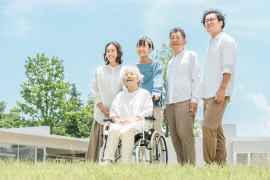 A three-generation family visiting a senior care facility or hospital.