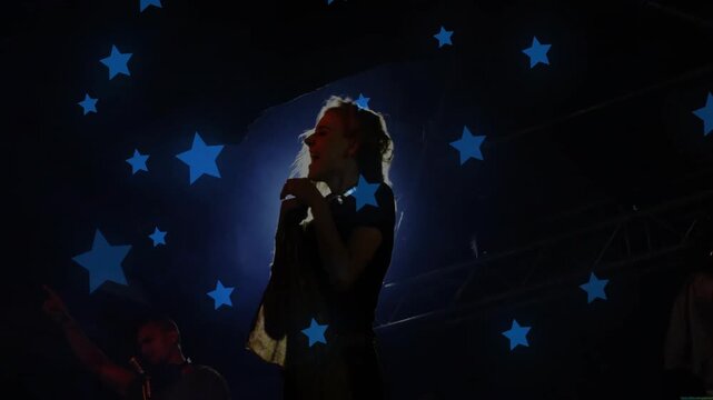 Music lead singer leaning swinging, singing with mic, whipping hair under halo blue stars floating