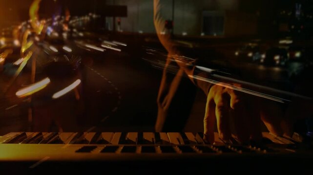 Right hand entering player hands on keyboard, practicing music ending chord as light trails passing
