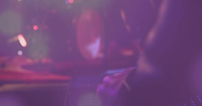 Female keyboardist playing synth under purple lights, camera pulling back to reveal live music