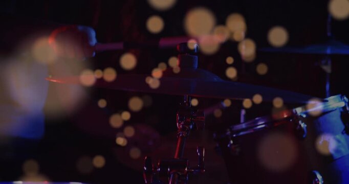 Drummer entering, striking cymbal and snare, driving rhythmic music with floating bokeh across kit
