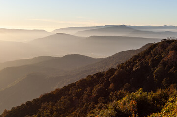 Obraz premium Phu Ruea National Park, Thailand. Misty mountain landscape at sunrise. Layered hills covered in forest. Scenic foggy view from a high vantage point.