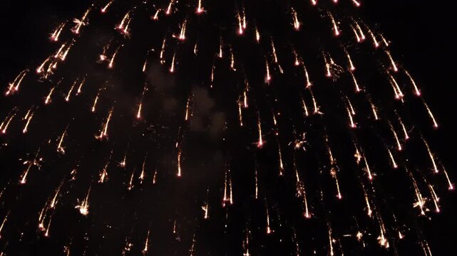 Vibrant fireworks exploding in the night sky with bright sparks and smoke trails everywhere