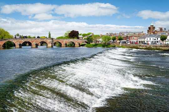 Dumfries town and Devorgilla Bridge seen across the weir on the River Nith in the Dumfries and Galloway region of the Southern Uplands of Scotland