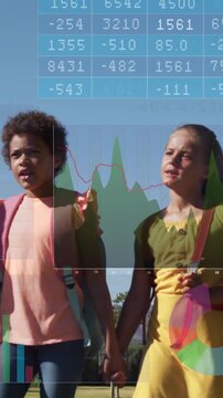 Vertical video: Girls walking hand-in-hand toward camera zooming, charts over backpacks for school