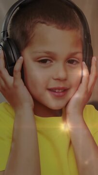 Vertical video: Child on sofa placing headphones, adjusting and hearing music with overlay drifting