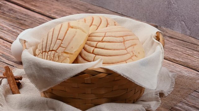Traditional Mexican sweet bread Conchas in a basket with cinnamon and eggs, aerial view