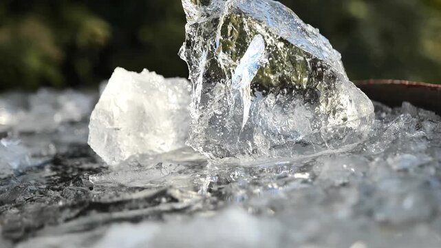 Ice. A piece of clear ice in a frozen slush against a blurred garden background. Frost and cold weather. 