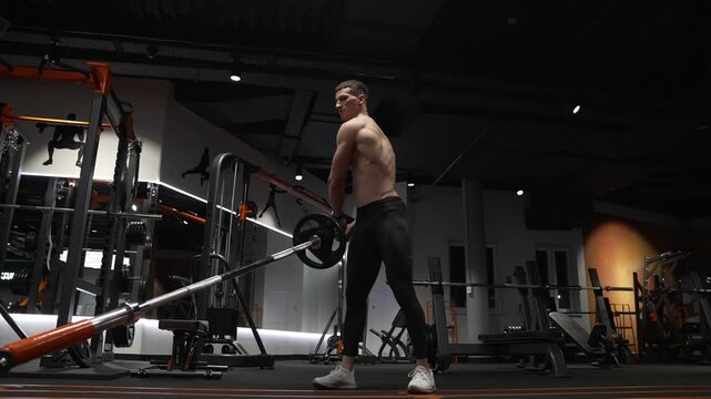 Strength and fitness. Muscular sportsman in sport gym do landmine exercise. Sport sportsman with barbell landmine in gym. Bodybuilder in sport gym do landmine exercise