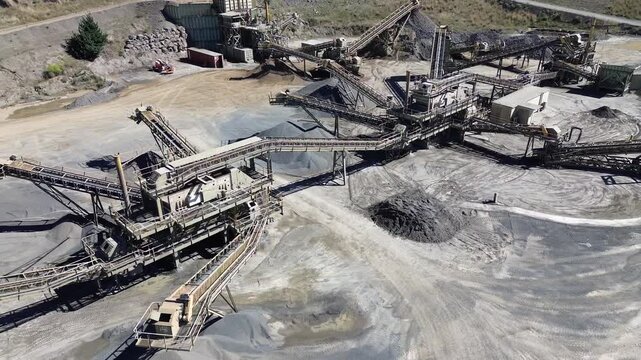 Aerial drone view of gravel quarry with conveyor belt system and aggregate processing plant