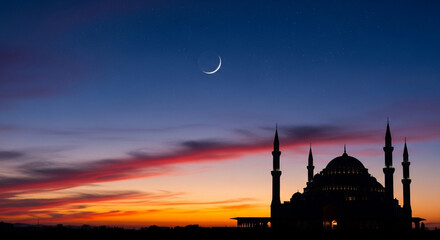 Silhouette of a mosque against a vibrant sunset sky with a crescent moon © Hridoy