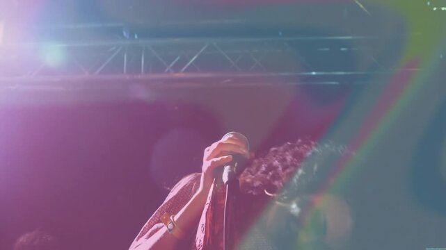 Female singer singing into mic and creating lens flares while doing hair flip boosting music energy