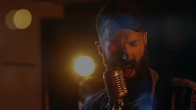 Drummer starting beat, camera cutting to lead singer singing into vintage mic, raising band energy