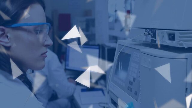 Lab tech touching controls, starting test and watching display while triangle overlay partly hiding
