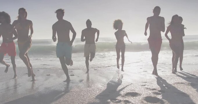 Eight adults running to surf on seeing waves, overlaying ripple over runners for travel ad