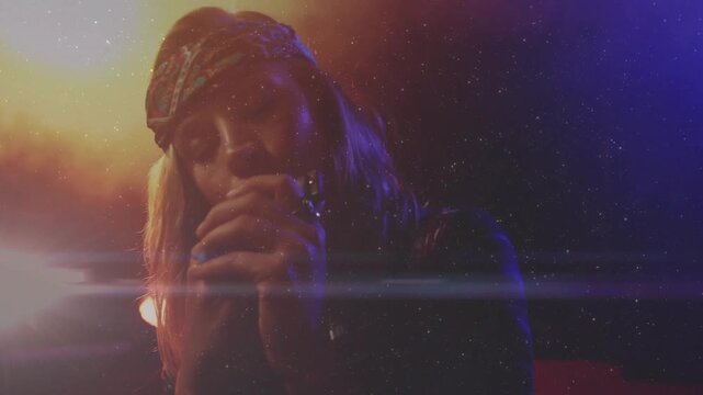 Music singer reacting to backlight rising showing face holding mic engaging audience amid flare