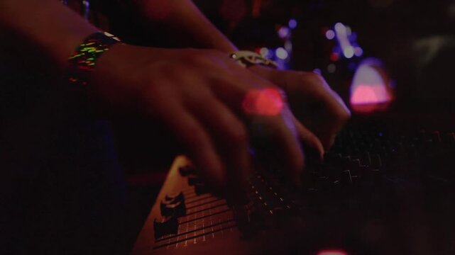 Vertical video: Female musician hands pressing pad, plucking strings, adjusting tuning for live set