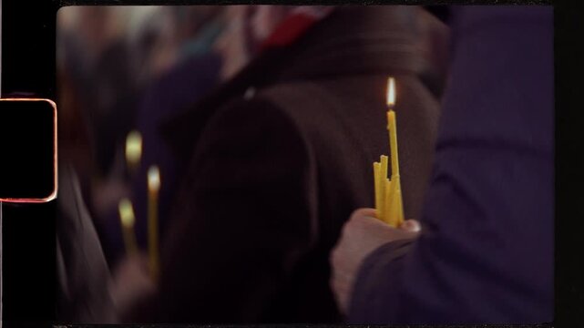 Person holding lit candles in religious procession