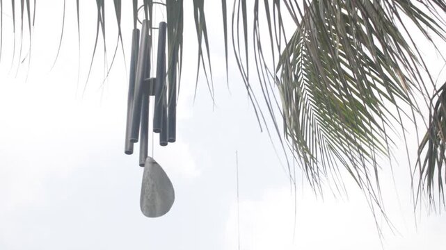 Wind chime hung  at outdoor among trees swaying  