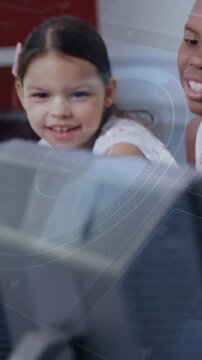 Vertical video: Two students leaning at PC, monitor shifting revealing smiles while learning