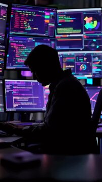 Silhouette coder at multimonitor workstation displaying colorful code and analytics dashboards latenight security engineer monitoring alerts, backend developer debugging terminal logs, data