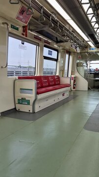 Bekasi, Indonesia - March 21, 2026: Priority seating area with red leather chairs and accessibility icons inside a modern Indonesian commuter train carriage