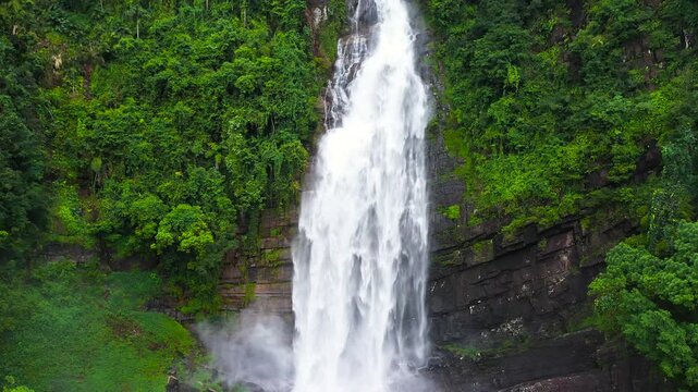 A tropical waterfall in a mountain canyon surrounded by jungle. Mapalana Falls. Sri Lanka.